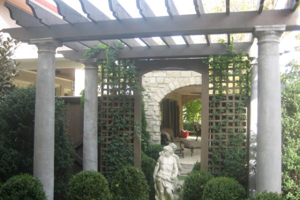 a pergola was constructed for privacy from the neighbor and a framed mirrored reflects onto the covered porch